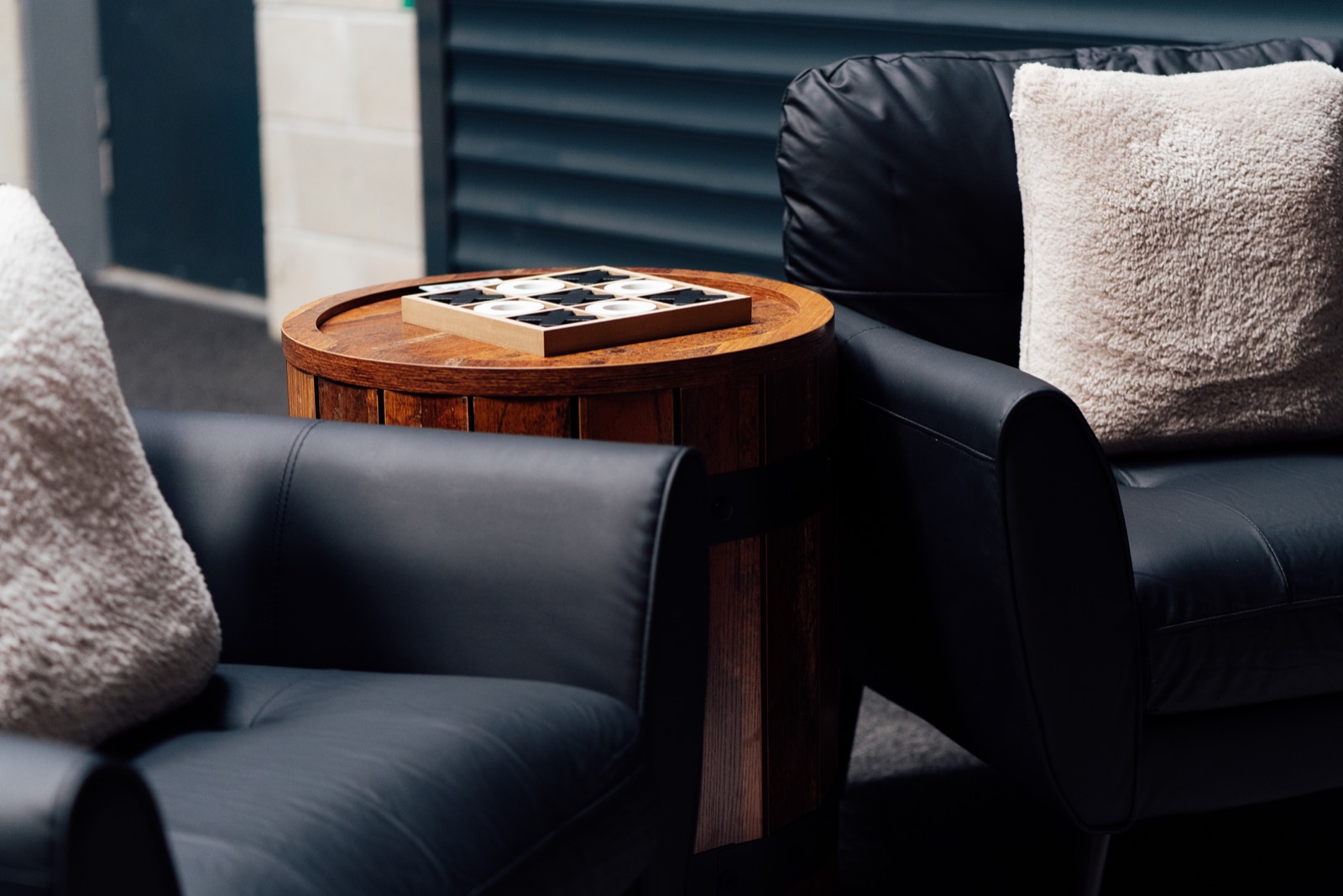 Leather chairs with a barrel table and noughts and crosses