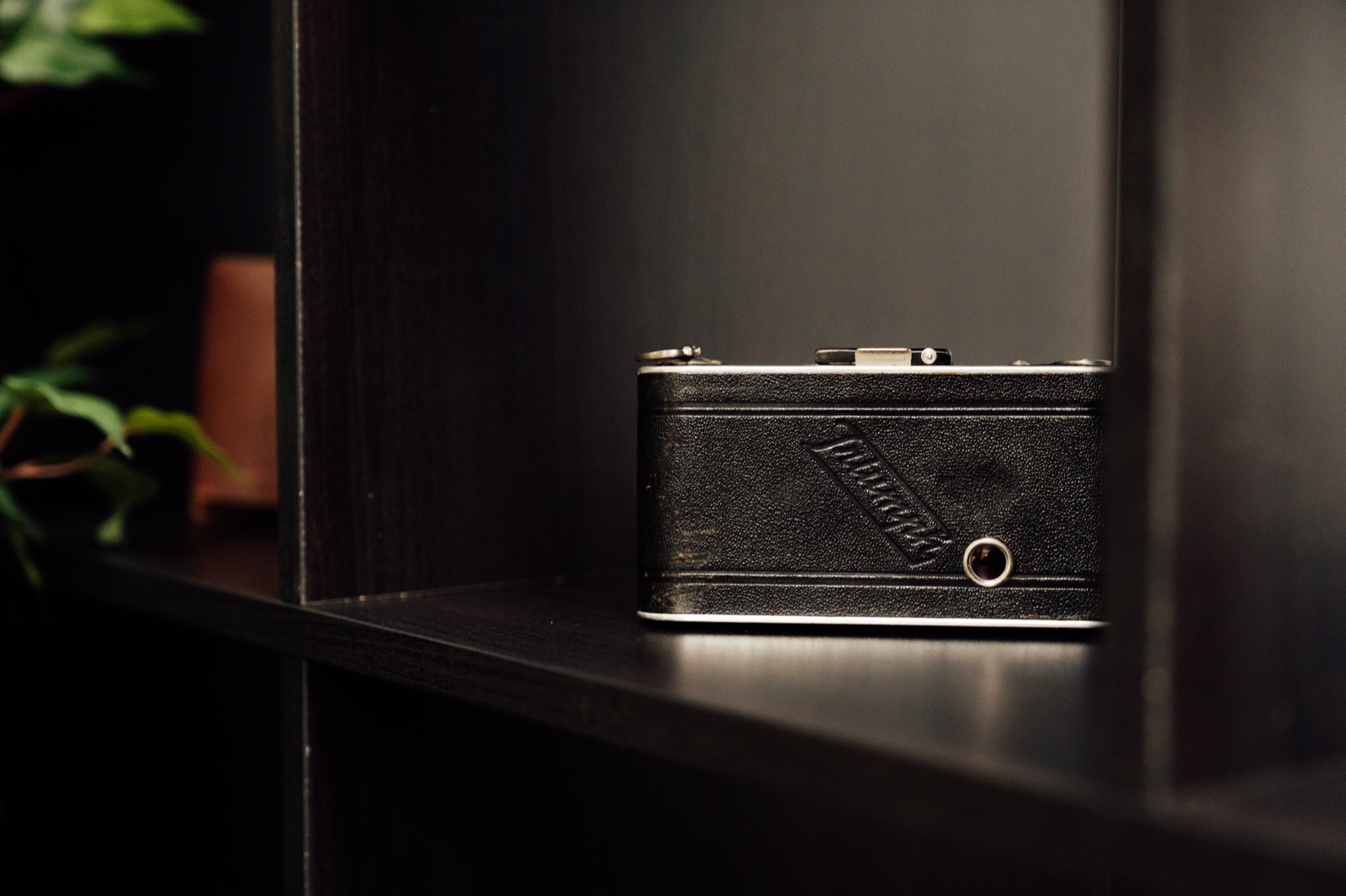 Vintage camera on a dark studio shelf